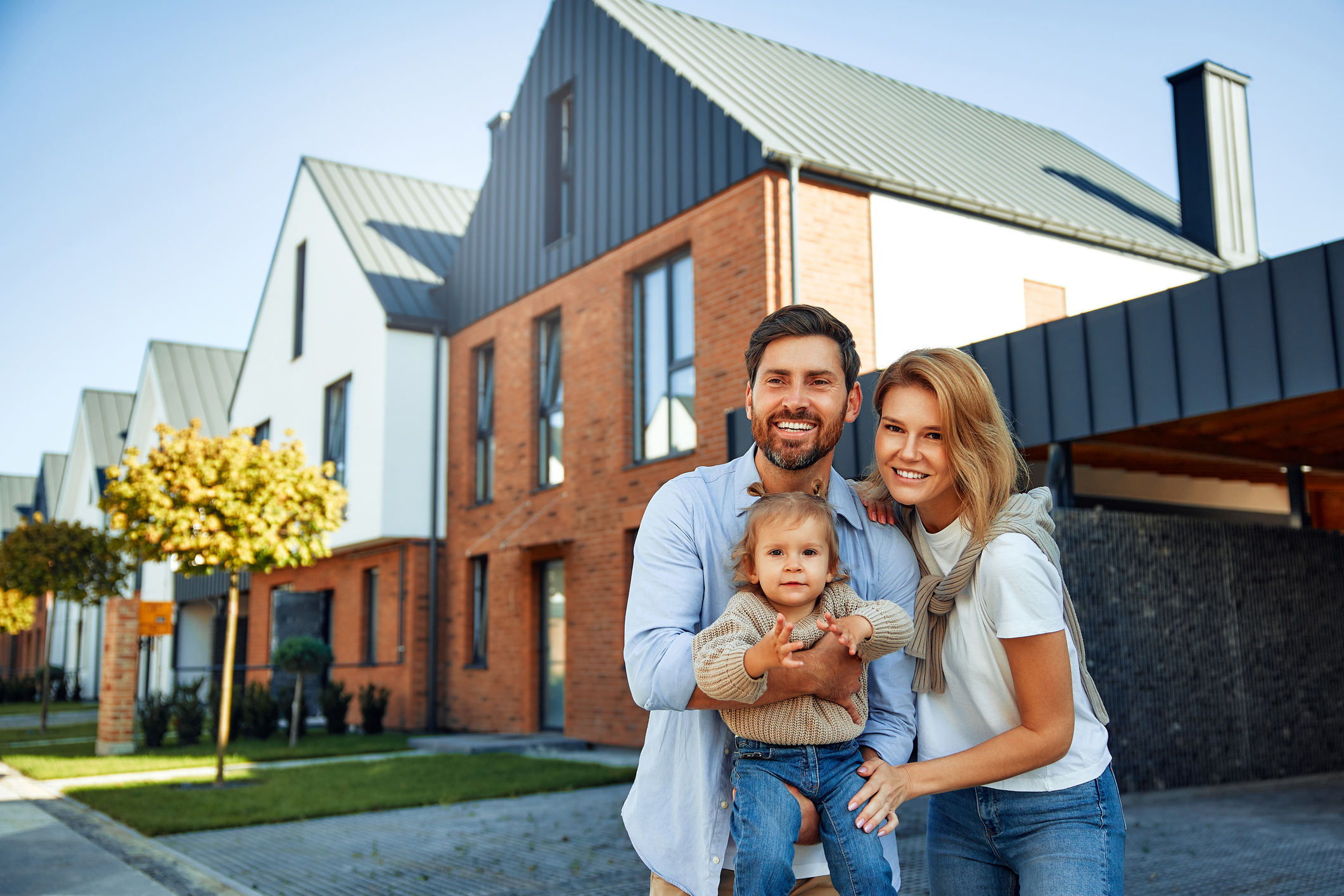Glückliche Familie vor ihrem Zuhause – Hausverwaltung ImmoService365